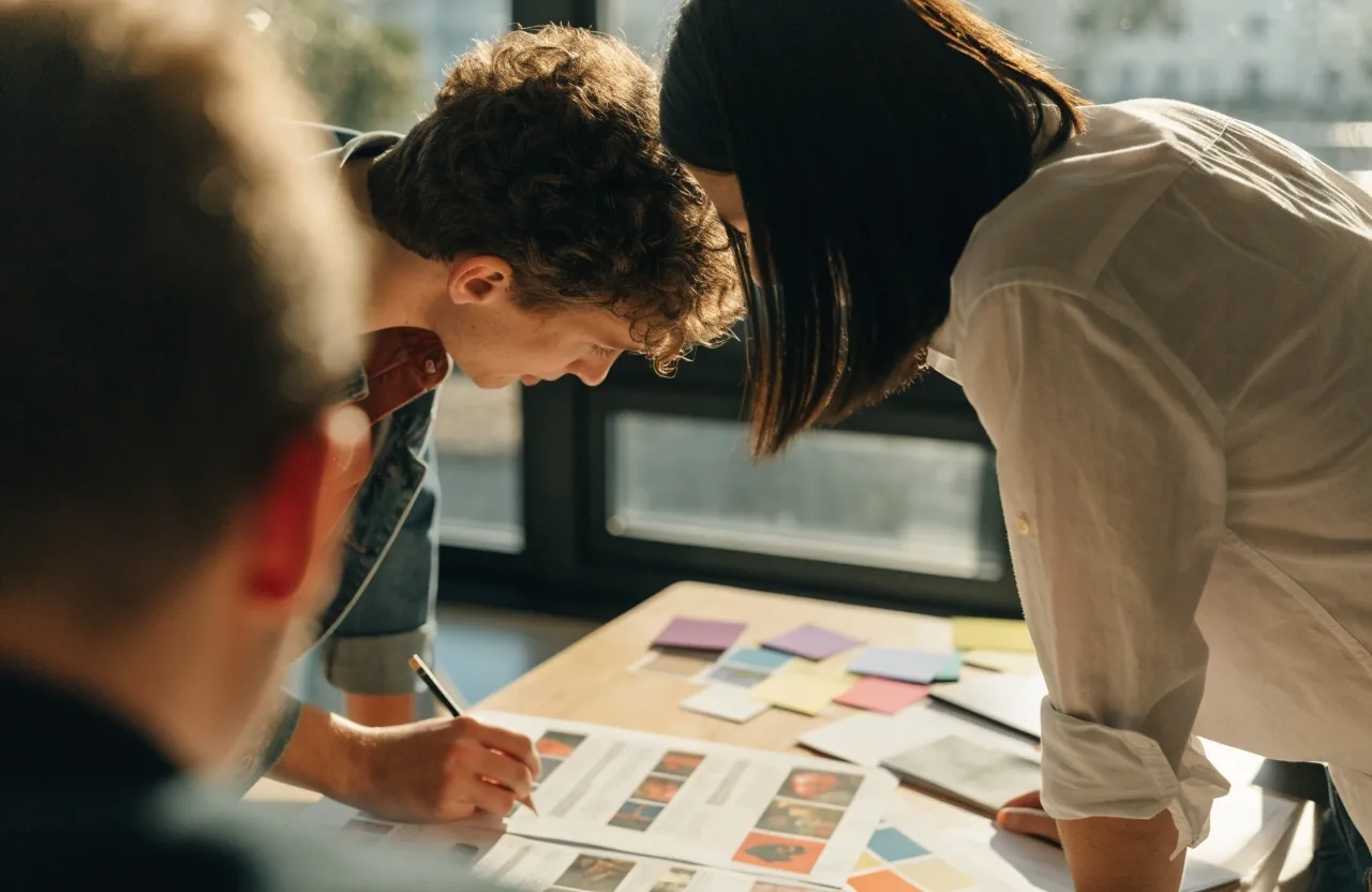 Colleagues reviewing work together in a bright room at midday